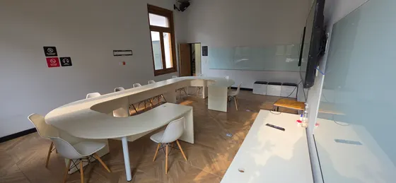 Aula de ISDI México con mesa en herradura y pantallas