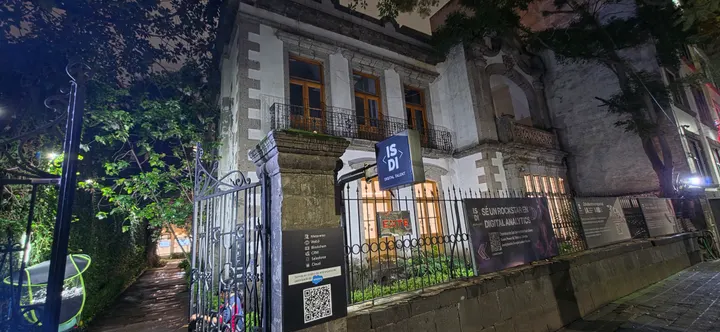 Fachada y reja de la casa de Marsella 45 de noche, con el letrero de ISDI