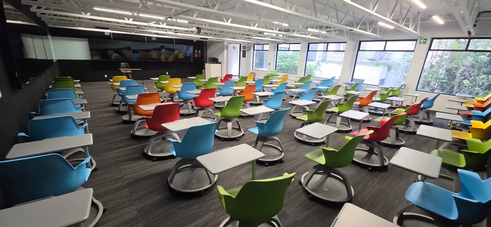 Salón de talleres de ISDI México con sillas de colores y ventanales